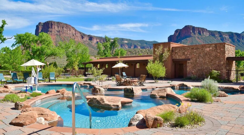 Rock-lined outdoor pool facing red rock mountains at Gateway Canyons Resort in the off-the-grid lodges area. 