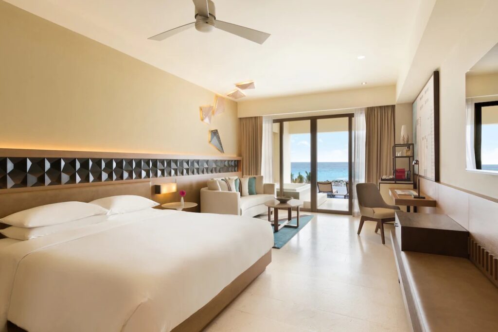 Bright, airy hotel room with a large bed and balcony at Hyatt Ziva Cancun. 