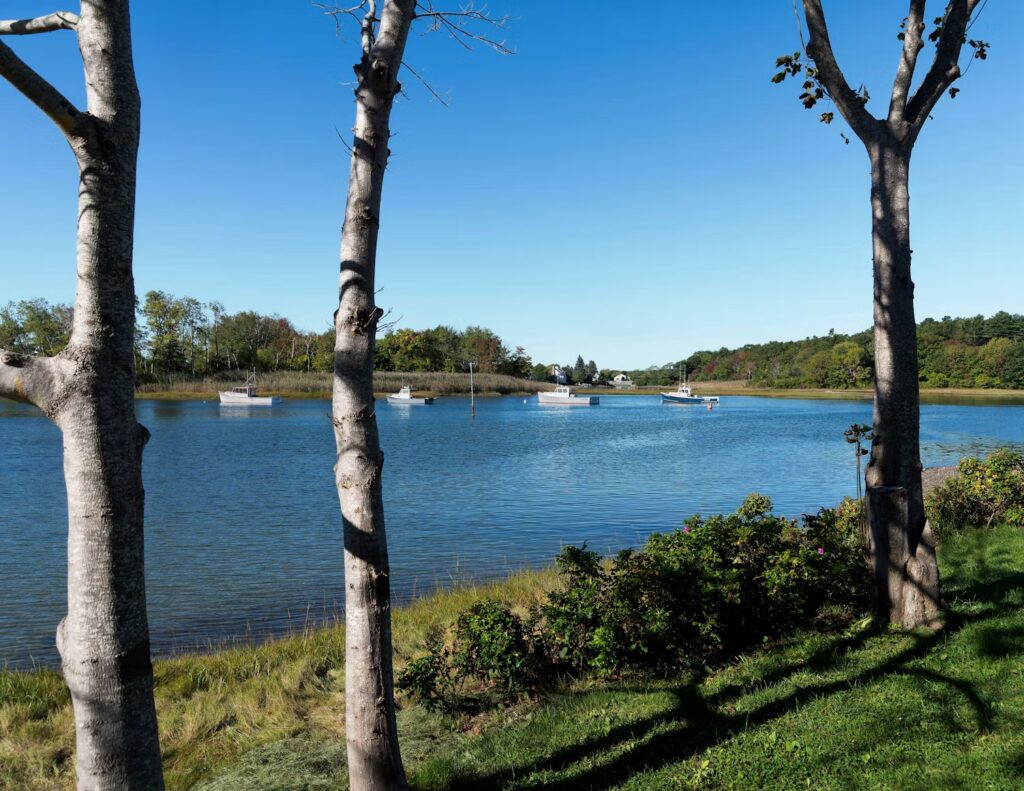 Small boats moored in a calm, scenic harbor in Kennebunkport. 