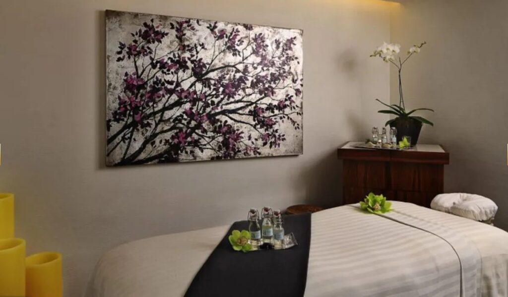 A tranquil spa treatment room with soft lighting and a massage table set up at Las Alcobas.