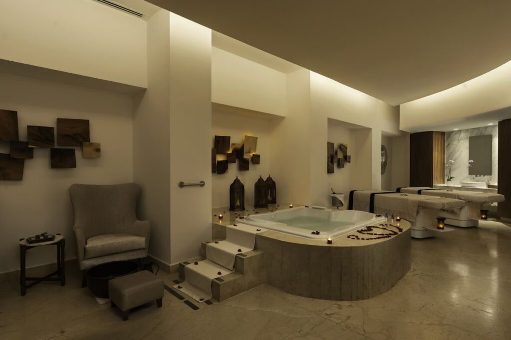 Serene spa interior featuring a central jacuzzi and massage tables at Le Blanc Spa Resort. 
