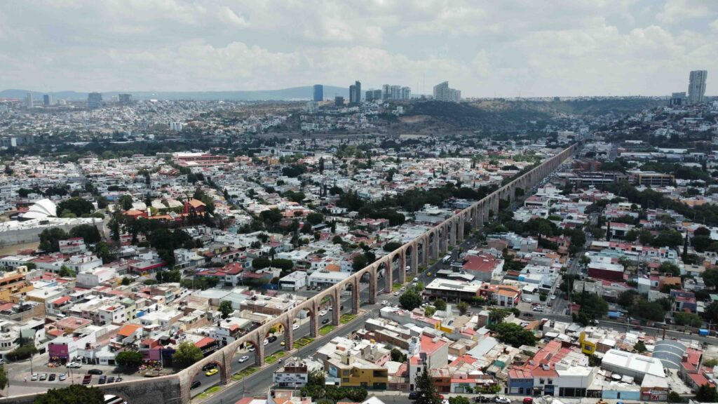 The impressive stone arches of the 18th-century aqueduct stretching across the modern cityscape of Querétaro.