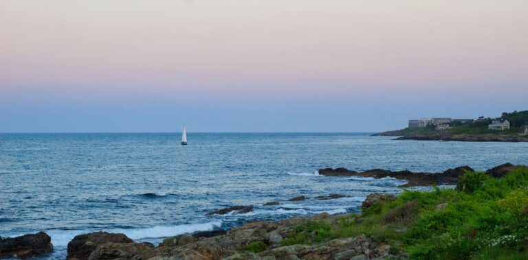 12 Best Things to Do in Ogunquit, Maine (Cliffs, Coves & Itineraries) A sailboat cruising along the rocky coastal waters, representing best things to do in Ogunquit Maine.
