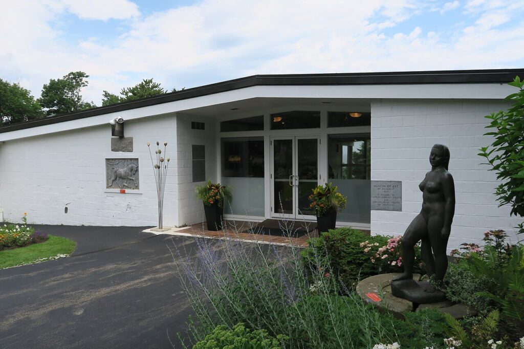 The white exterior and entrance of the Ogunquit Museum of American Art with a bronze statue, Ogunquit, Maine.