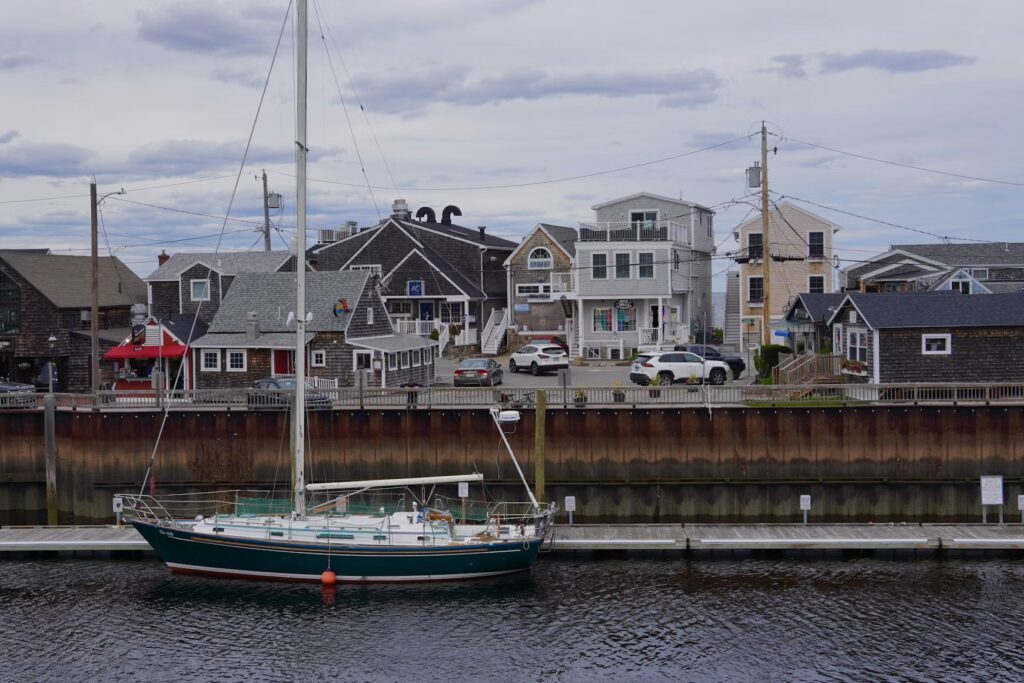 A sailboat docked near the charming waterfront buildings of Perkins Cove in Ogunquit. 