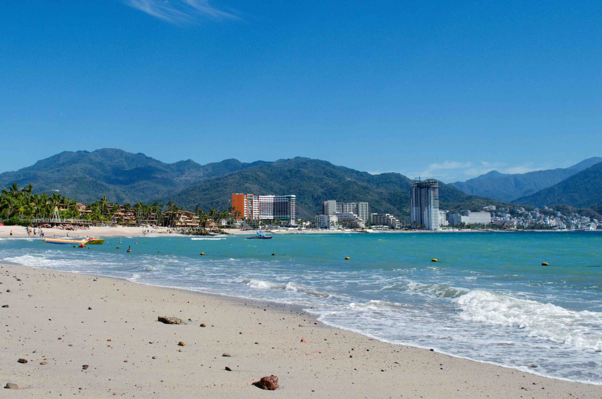 A scenic beach and mountain backdrop where November through April is the best time to visit Puerto Vallarta. 