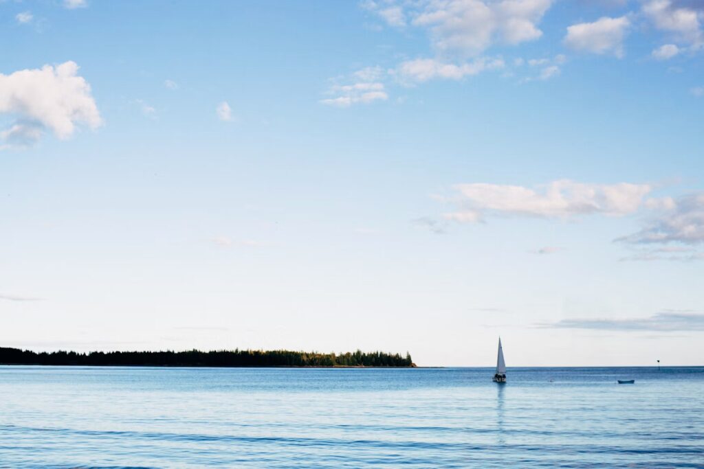A single sailboat drifting on the calm blue waters near Rockport. 