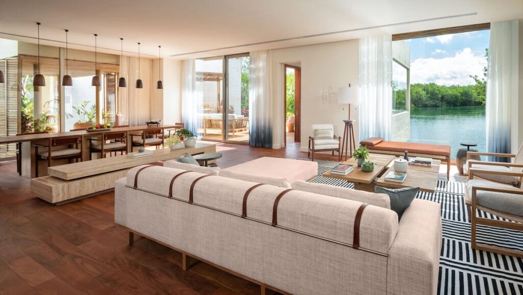 A spacious, elegantly designed living room suite overlooking the calm lagoons at Rosewood Mayakoba.