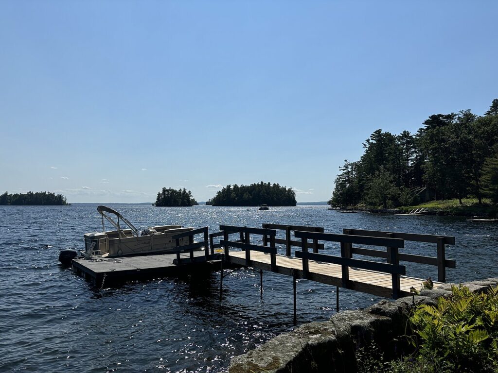A wooden dock extending into the deep blue waters of Sebago Lake. 