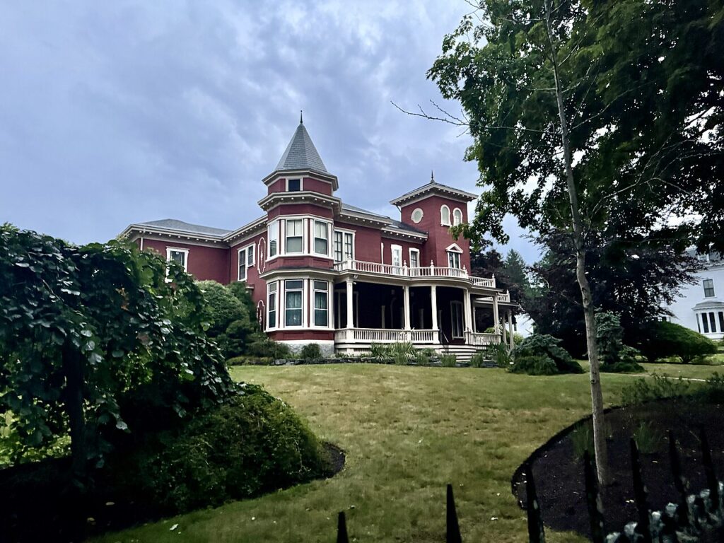 The red Victorian Gothic exterior and wrought-iron gate of Stephen King's famous house in Bangor.