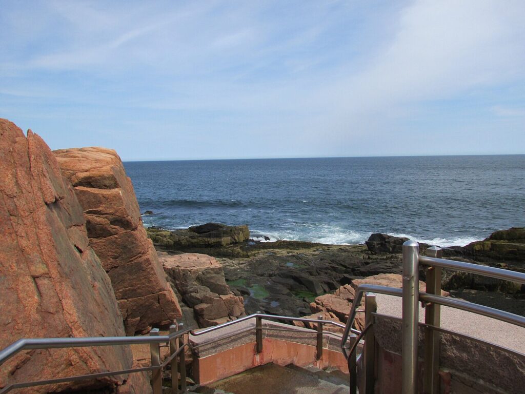 Concrete viewing platforms and stairs built into the rugged pink granite cliffs at Thunder Hole.