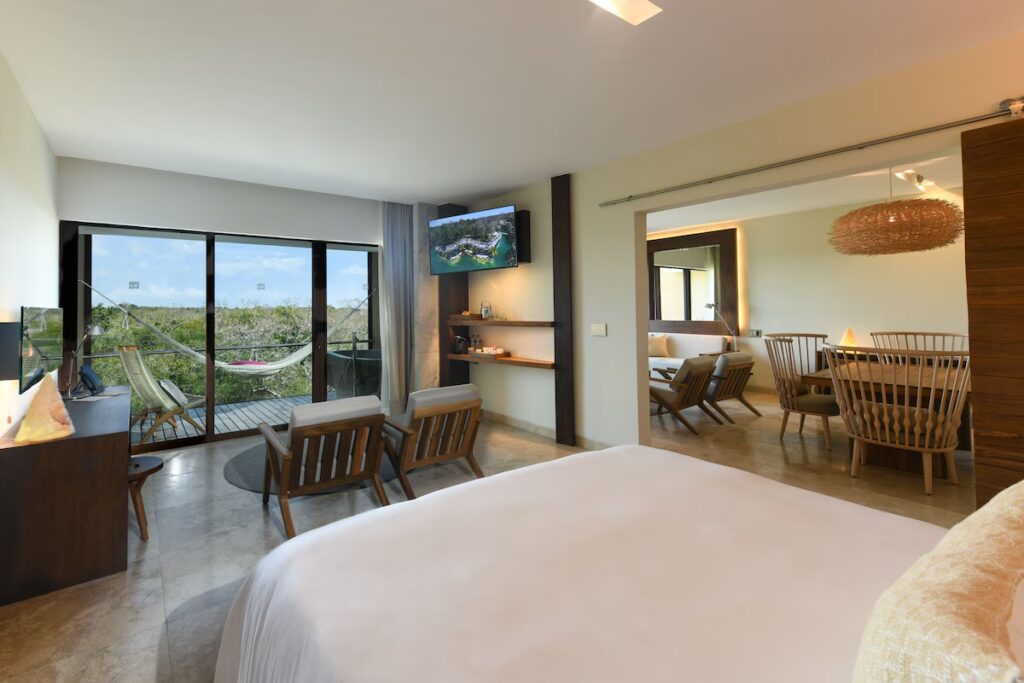 Modern hotel room featuring a balcony with a hammock at Hotel Xcaret Mexico. 