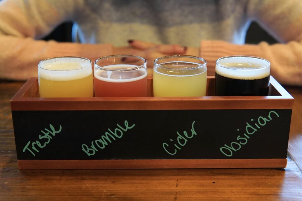 A wooden flight board holding four small glasses of craft beer at a local brewery in York, Maine.