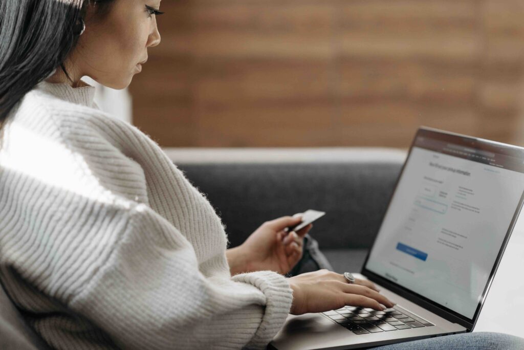 A person using a credit card to book a flight on a laptop.
