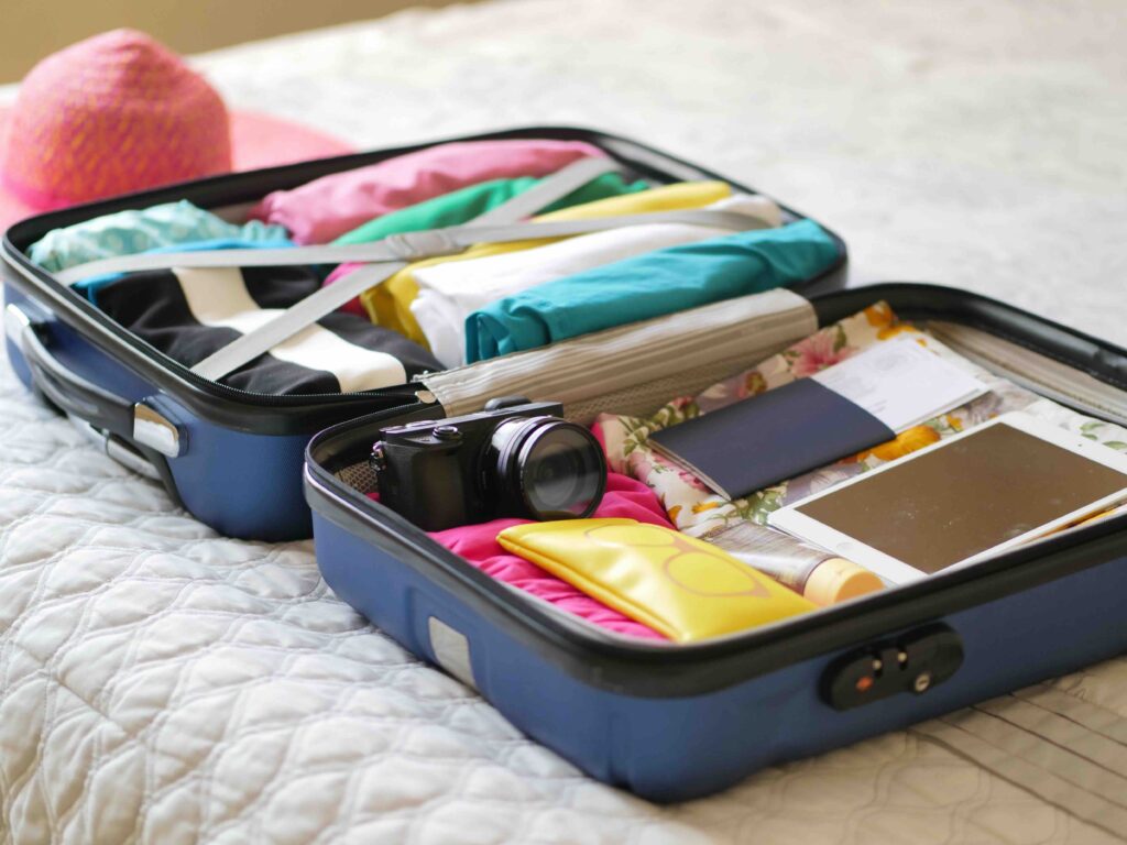 A packed blue suitcase with clothes organized using packing cubes.