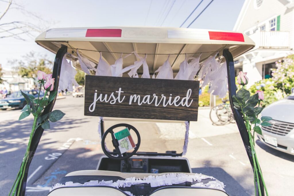 A golf cart decorated with a "just married" sign and white paper streamers parked on Peaks Island. 