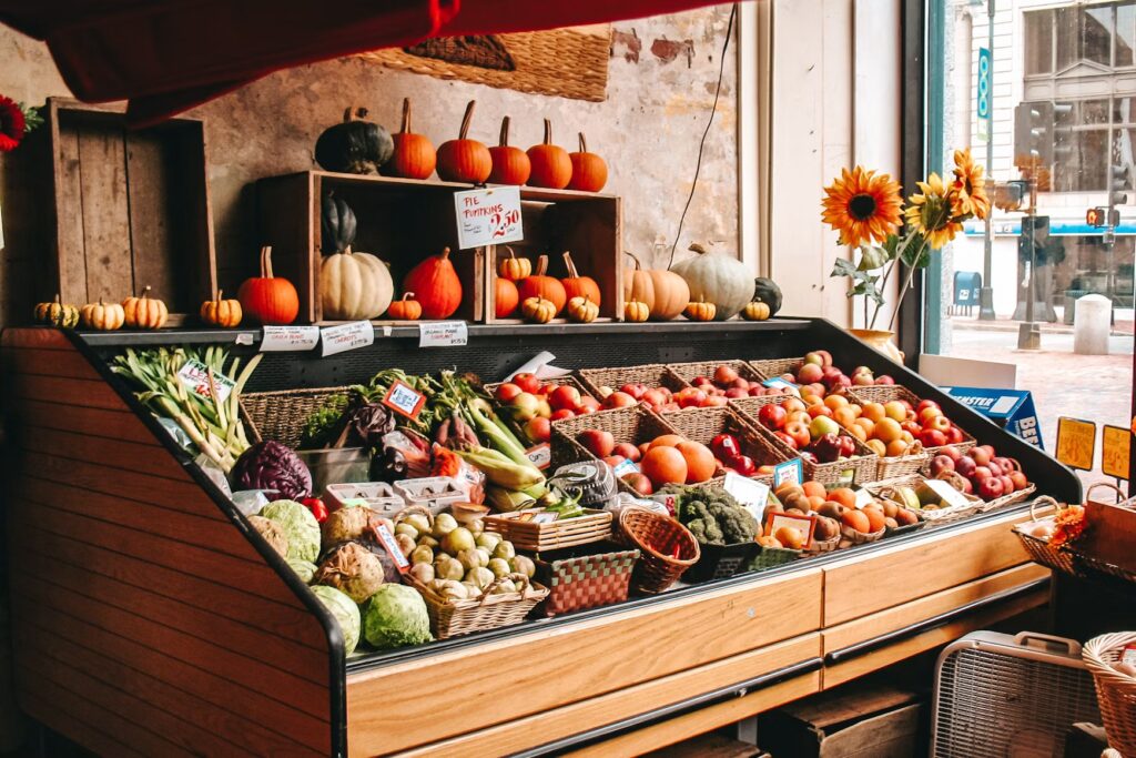 Vibrant outdoor market stall overflowing with fresh pumpkins and apples in Portland, Maine.
