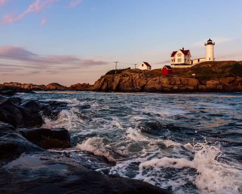 9 Best Things to Do in York, Maine: From Nubble Light to Mount A Stunning sunset view of Nubble Lighthouse with crashing waves, perfect for top things to do in York Maine.