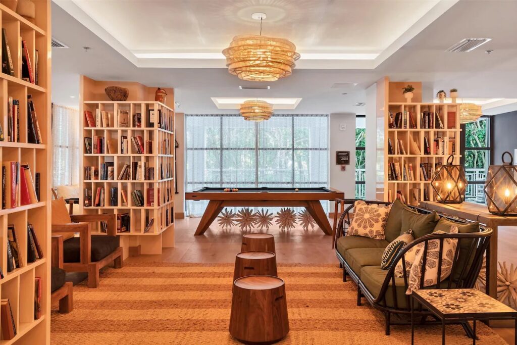 An inviting resort lounge area featuring plush couches, a pool table, and built-in bookshelves.