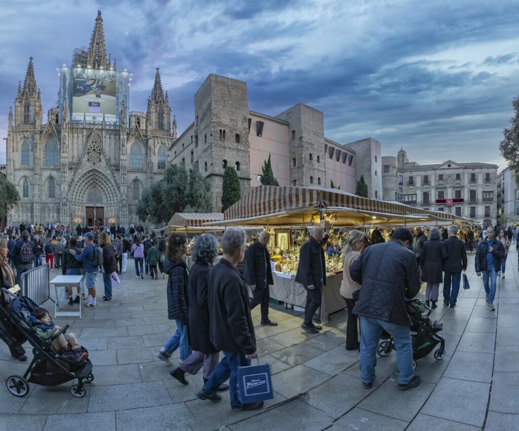 Shoppers browsing traditional stalls at the Fira de Santa Llúcia market outside the Gothic Cathedral.