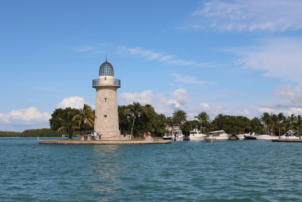 The historic Boca Chita Key lighthouse standing on a small island with boats docked in Biscayne National Park.