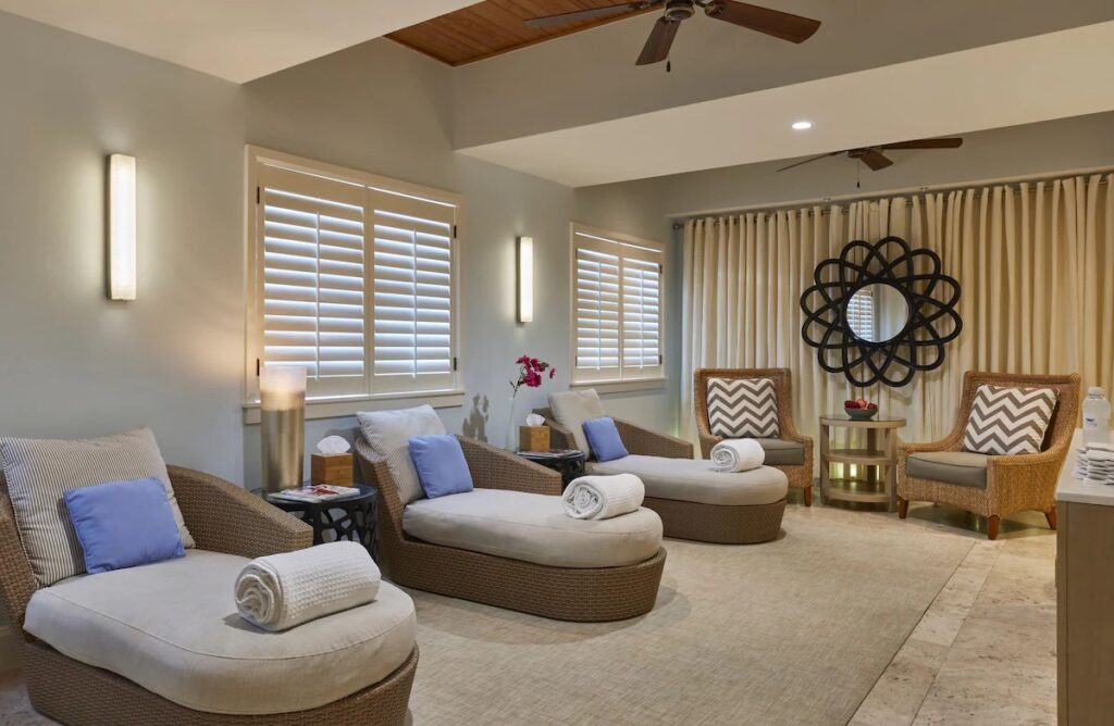 A relaxing spa lounge at Cheeca Lodge & Spa featuring comfortable woven chaise lounges and soft lighting.