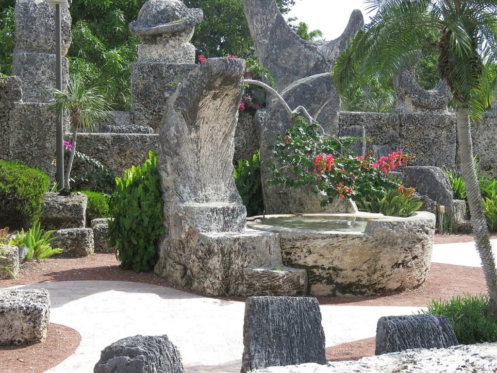 A carved stone crescent moon and star fountain in the gardens of Coral Castle.