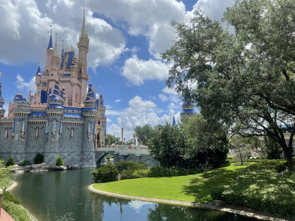 The iconic castle at a major Orlando theme park surrounded by lush greenery.