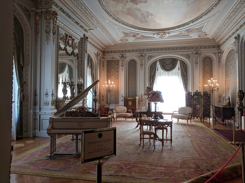 The opulent Flagler Drawing Room with a grand piano and painted ceiling.