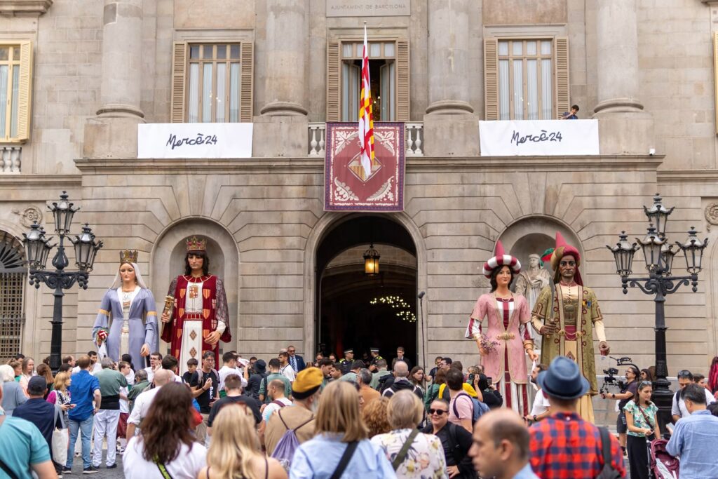 Crowd gathers in Barcelona's Gothic Quarter to see traditional giants during La Mercè festival.