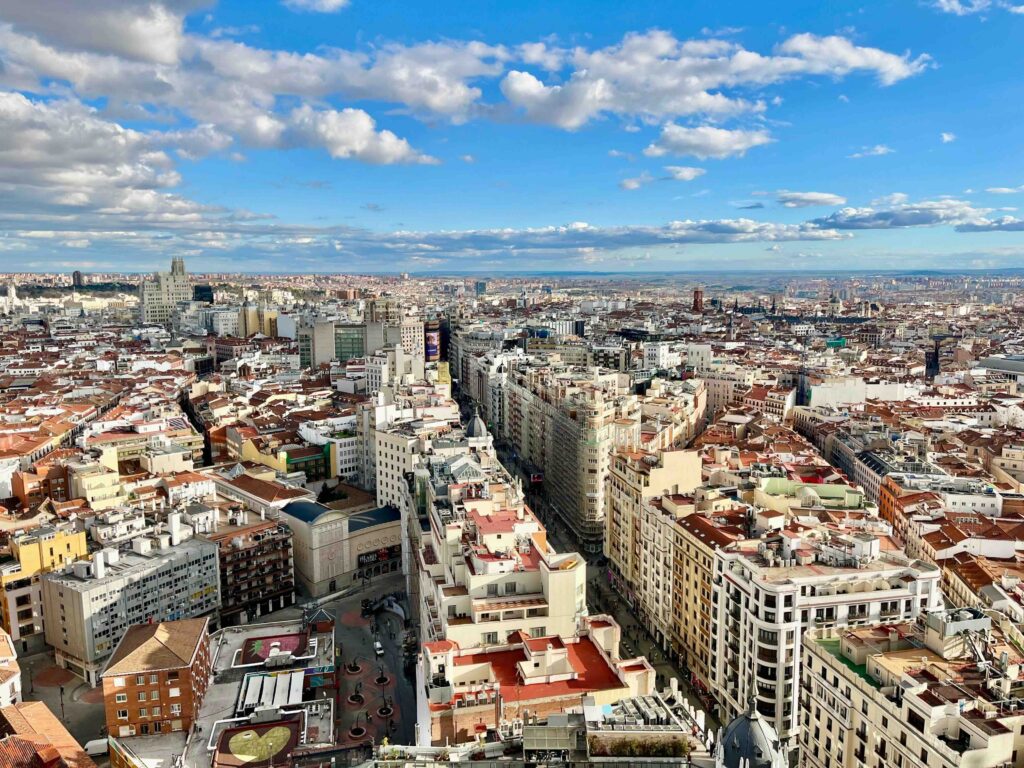 Wide aerial view of bustling city streets and architecture in Madrid.