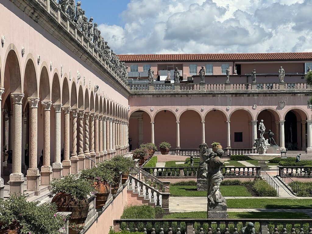 The elegant courtyard of The Ringling featuring a long colonnade and statues.