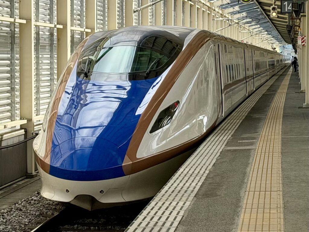Shinkansen bullet train at a station; plan local travel well to save money.