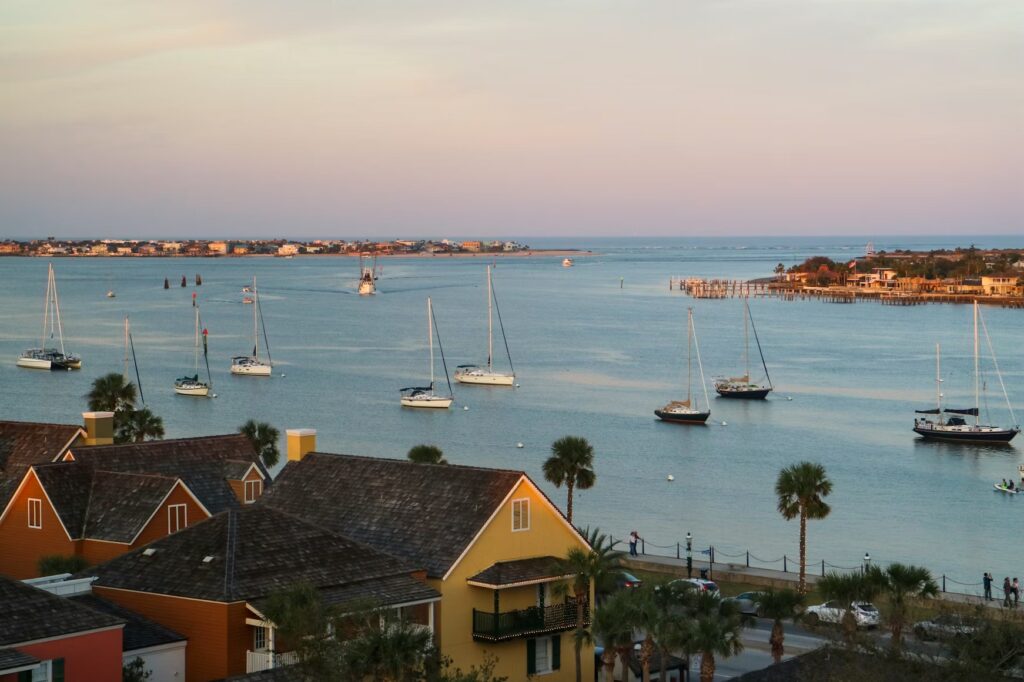 A scenic view of sailboats docked in a peaceful Florida harbor during sunset.