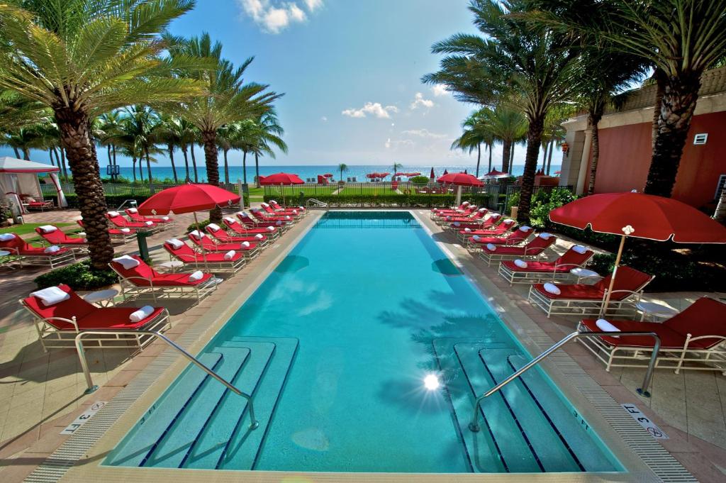 Red umbrellas and swimming pool cabanas for Florida resort credit bundles.