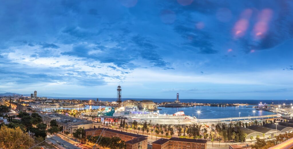 Panoramic view of Barcelona's harbor and skyline at dusk, a magical sight during the best time to visit Barcelona.