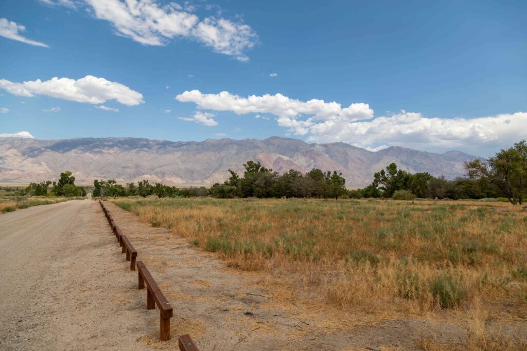 Dirt road beside open desert plain and mountain range at death valley camping spots.