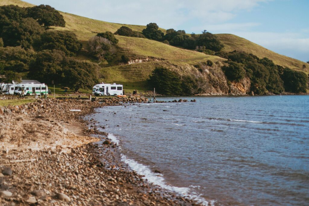 RVs parked along rocky ocean shoreline for oceanfront camping in California.