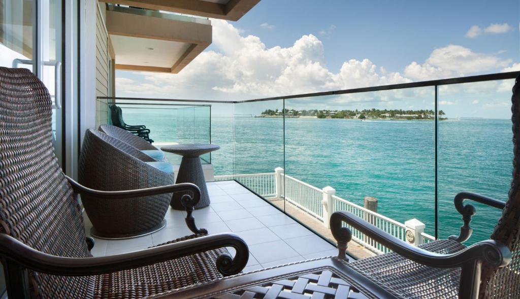 Private oceanfront balcony with wicker chairs at tranquil Key West adult-only Florida stay.