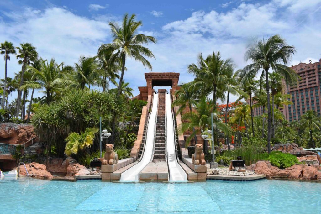 Steep water slide tower surrounded by palm trees at Aquaventure Waterpark, popular dubai sightseeings.