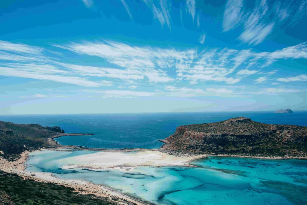 Aerial view of shallow pink sand lagoon and blue sea at famous Greece beaches.