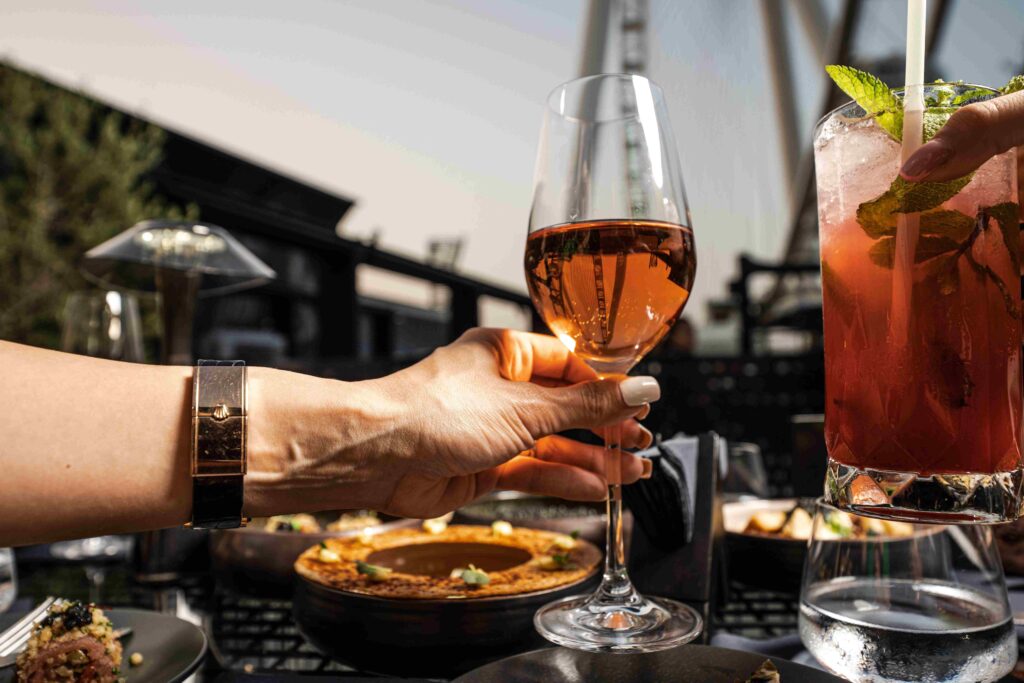 Person holding a glass at a luxury restaurant during top Dubai visiting months.