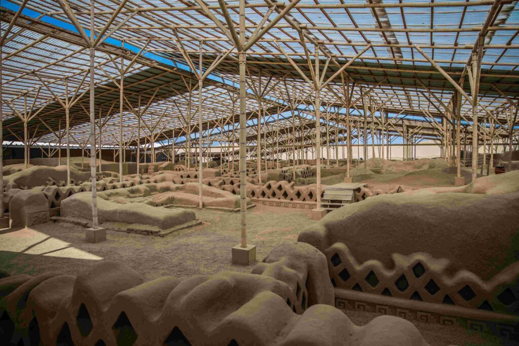 Adobe brick ruins under protective roof structure visited during cheaper time to visit Peru.