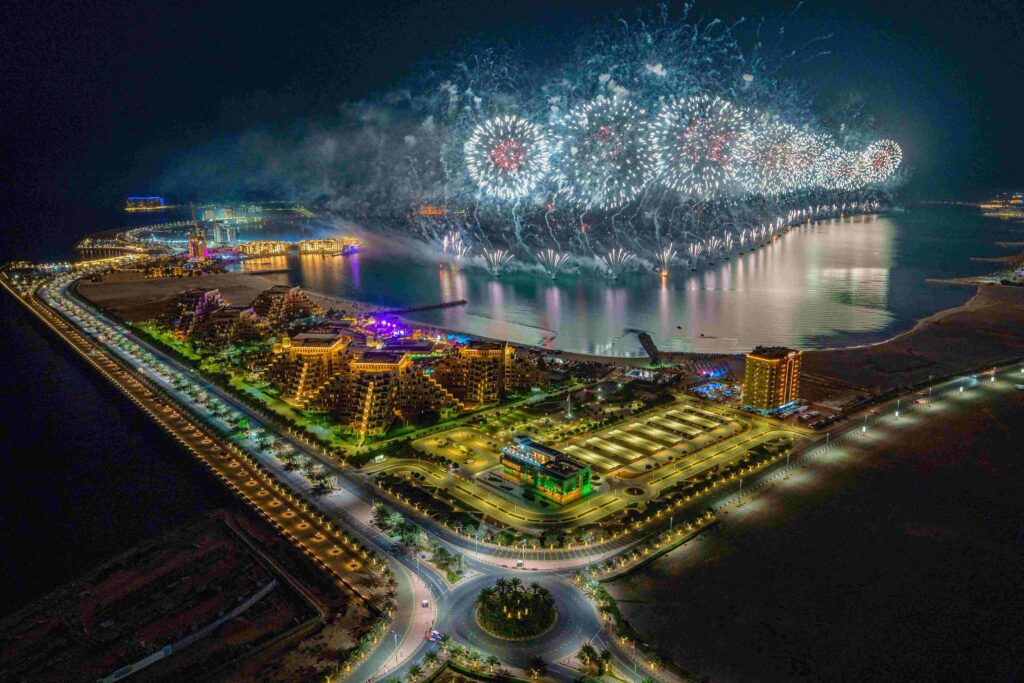 Spectacular fireworks over waterfront shoreline during ideal Dubai trip planning.