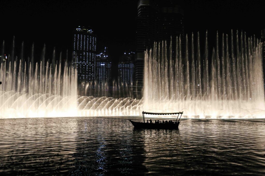 Water jets shooting high into the night sky during Dubai Fountain show, must-have for dubai travel itinerary.