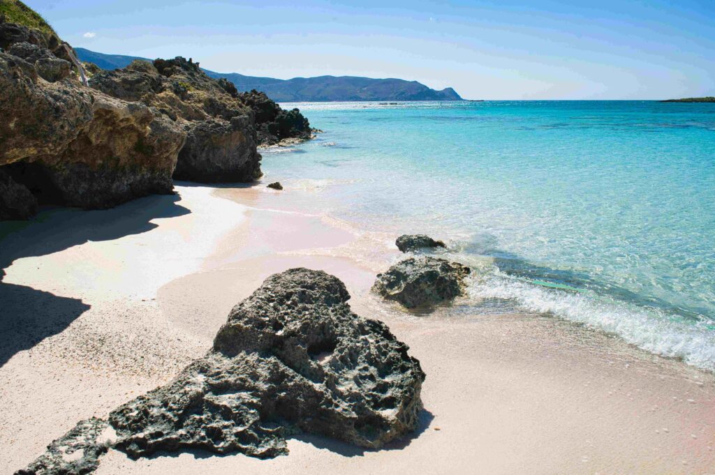 Clear turquoise water and rocky beach showcasing total islands in Greece.