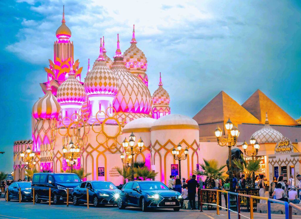 Brightly lit colorful palace pavilions and domes at Global Village, featured in the ultimate Dubai excursion guide.