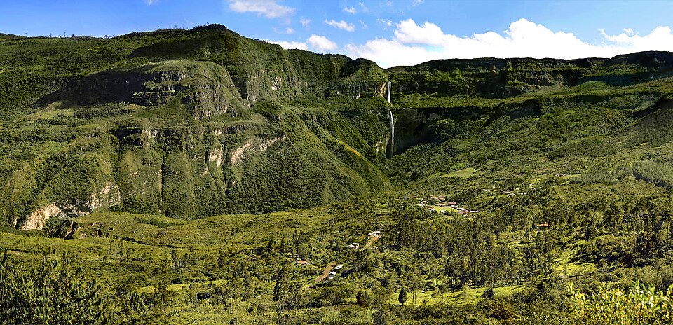 Tall Gocta Waterfall cascading down lush green vertical cliffs in Chachapoyas, Peru.