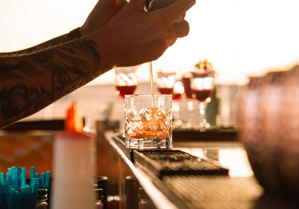 Bartender pouring signature cocktail at cliffside bar for Lima Peru vacation.