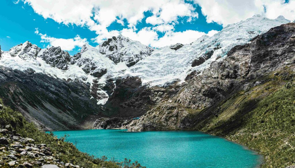 What is Peru Known For? 15 Things Beyond Machu Picchu Turquoise mountain lake surrounded by snow peaks, showing what is peru known for.